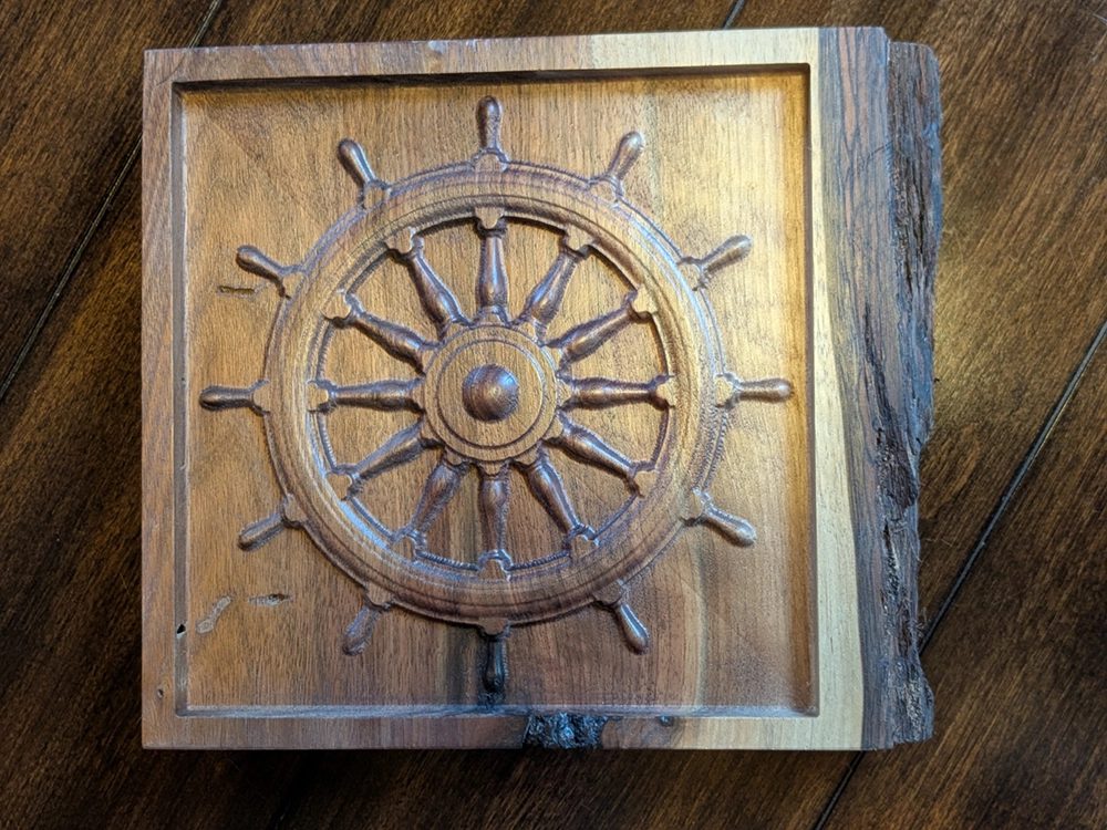 A carved ship’s wheel in hardwood